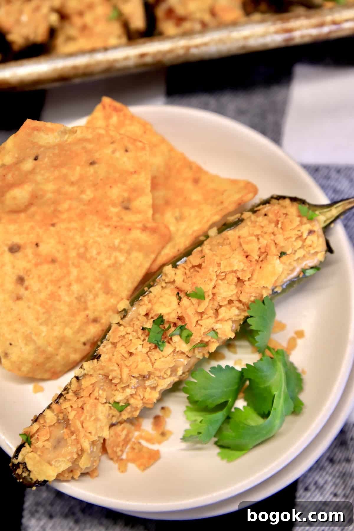 Nacho cheese jalapeno popper on a plate with Doritos chips.