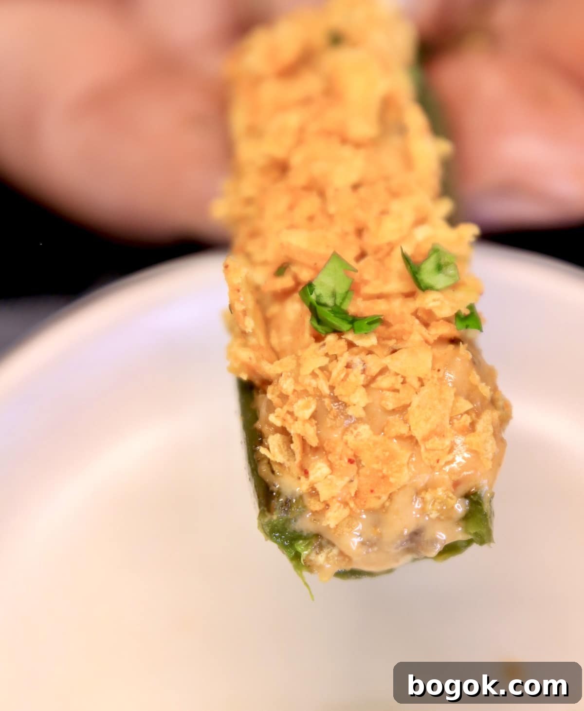 Closeup of Doritos Nacho Cheese Jalapeno Jalapeño Popper, held in hand.