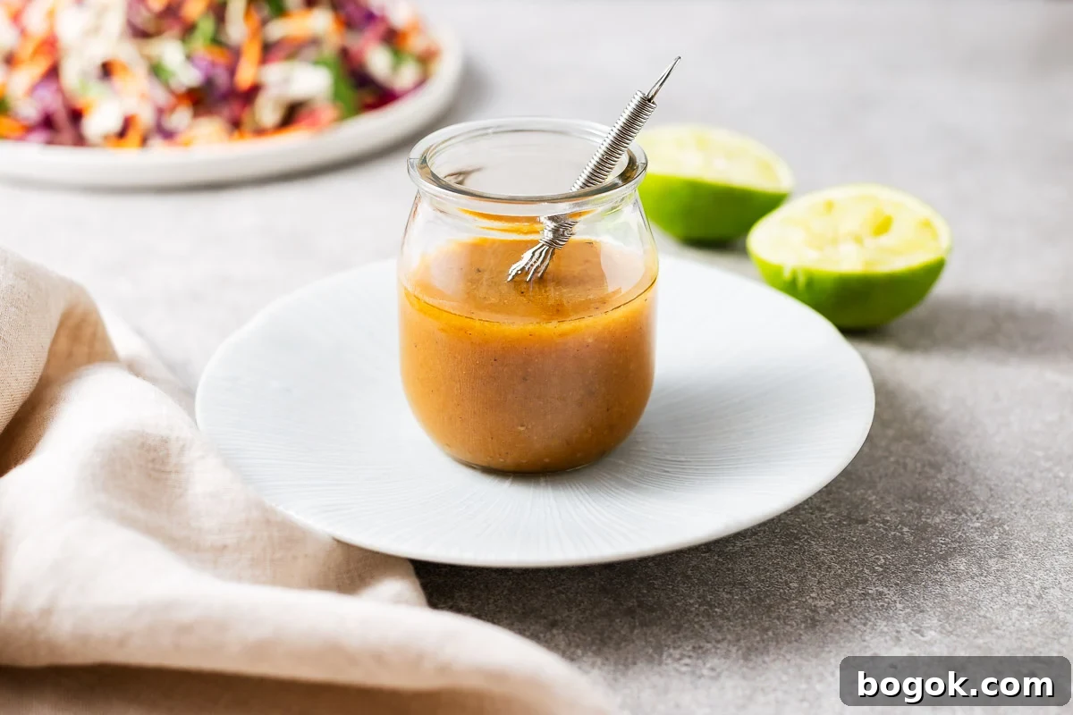 Miso Lime Vinaigrette Recipe — Tangy Asian Dressing 6 Homemade miso and lime vinaigrette in a glass jar with a salad in the background next to spent fresh limes.