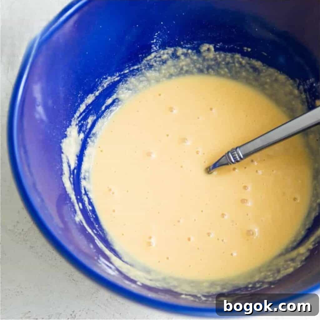 Fluffy Paleo Blueberry Pancakes: Grain-Free Breakfast Recipe 5 A bowl filled with pancake batter with a spoon in it.