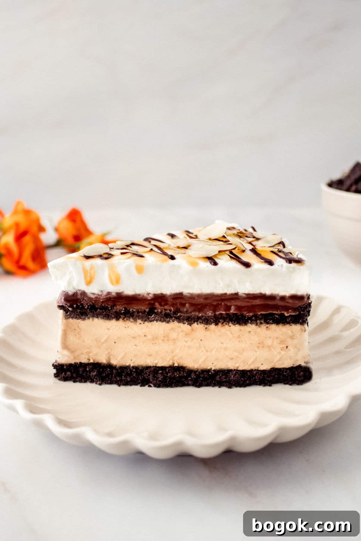 a side view of a slice of Billy Miner ice cream pie showing the layers of chocolate crust, coffee ice cream, fudge, and whipped topping