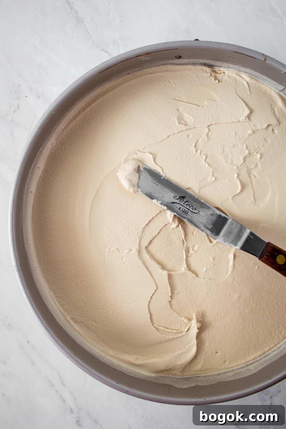 coffee ice cream being smoothed on top of chocolate crust