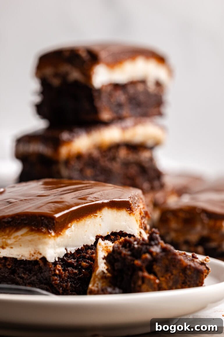 several homemade brownies with a white peppermint patty layer topped with glossy chocolate