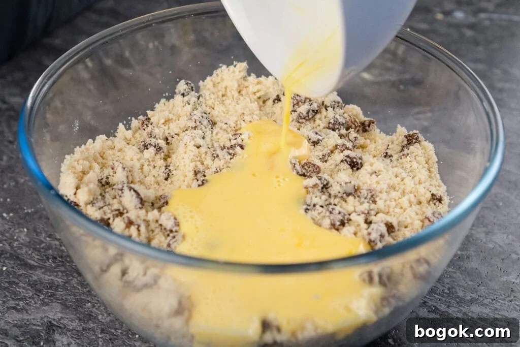 milk and egg mix added to rock cake mixture in a glass bowl