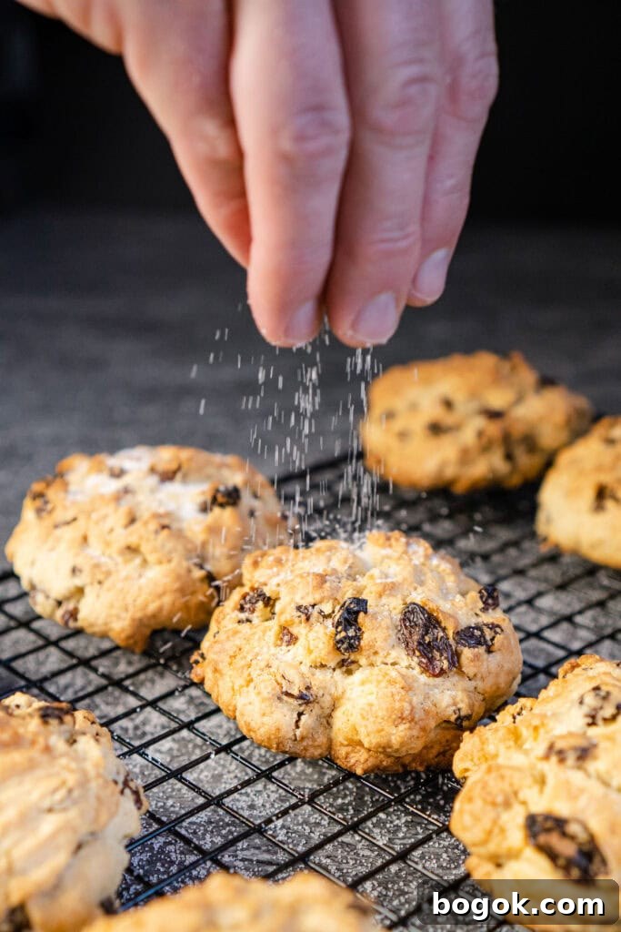 Sprinkling granulated sugar over the top of the rock cakes on a wire rack