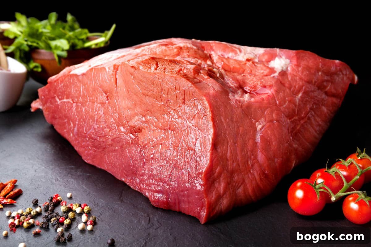 Beef Top Round on cutting board with tomatoes, the second best meat for beef jerky