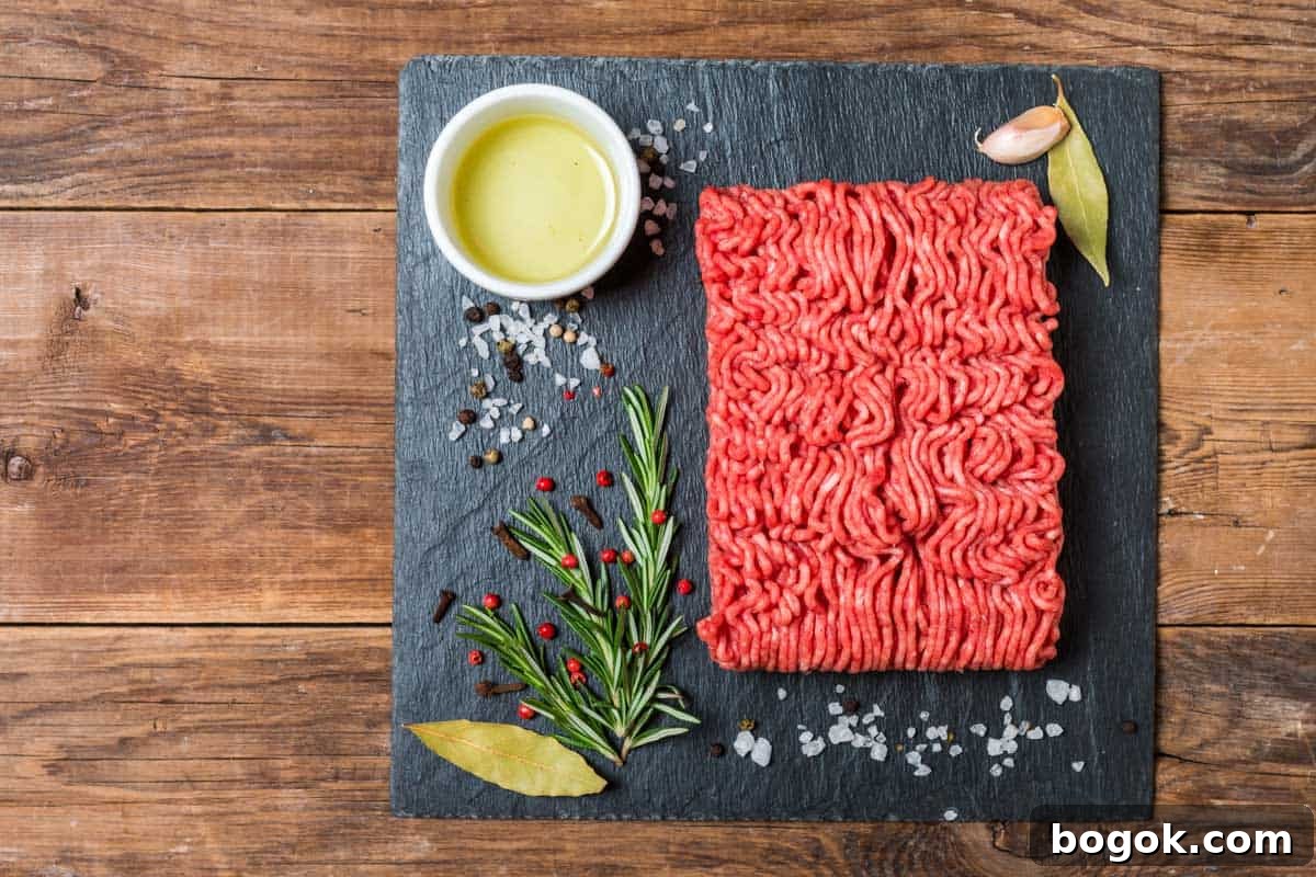 Ground meat on slate with spices for beef jerky