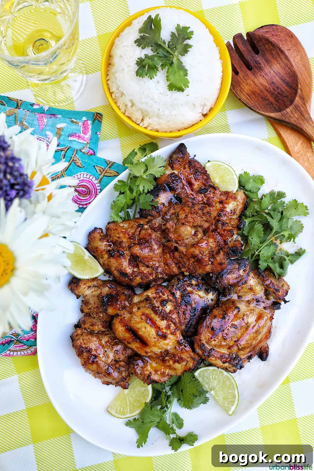 Philippine Chicken Inasal Recipe: Grilled Marinade & Tips 3 Filipino grilled chicken inasal on a platter near a vase of daisies and bowl of rice.