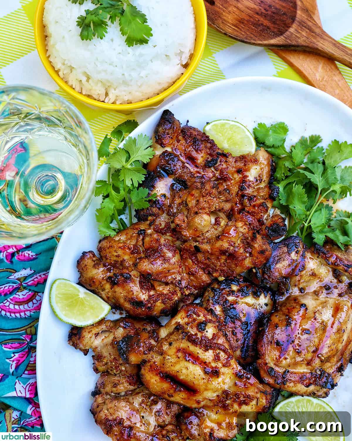 Philippine Chicken Inasal Recipe: Grilled Marinade & Tips 9 Filipino grilled chicken inasal on a platter near a glass of white wine and bowl of rice.