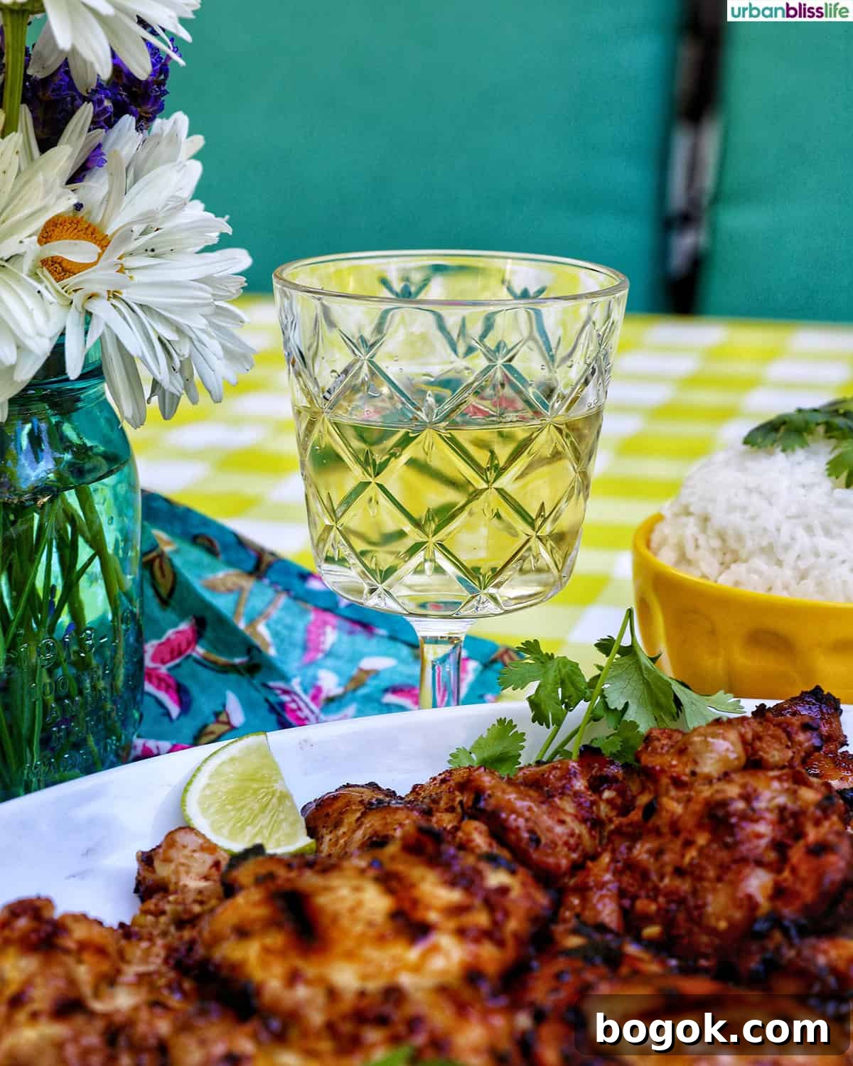 Philippine Chicken Inasal Recipe: Grilled Marinade & Tips 10 Filipino grilled chicken inasal on a platter near a glass of white wine and bowl of rice.