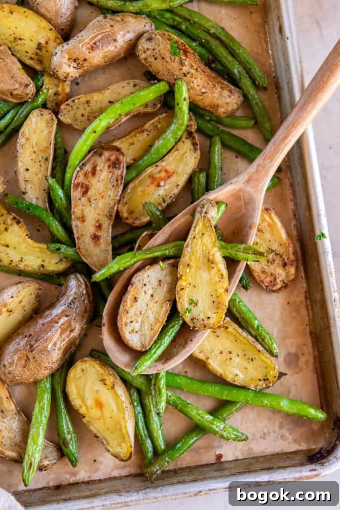 Roasted fingerling potatoes and green beans on a sheet pan.