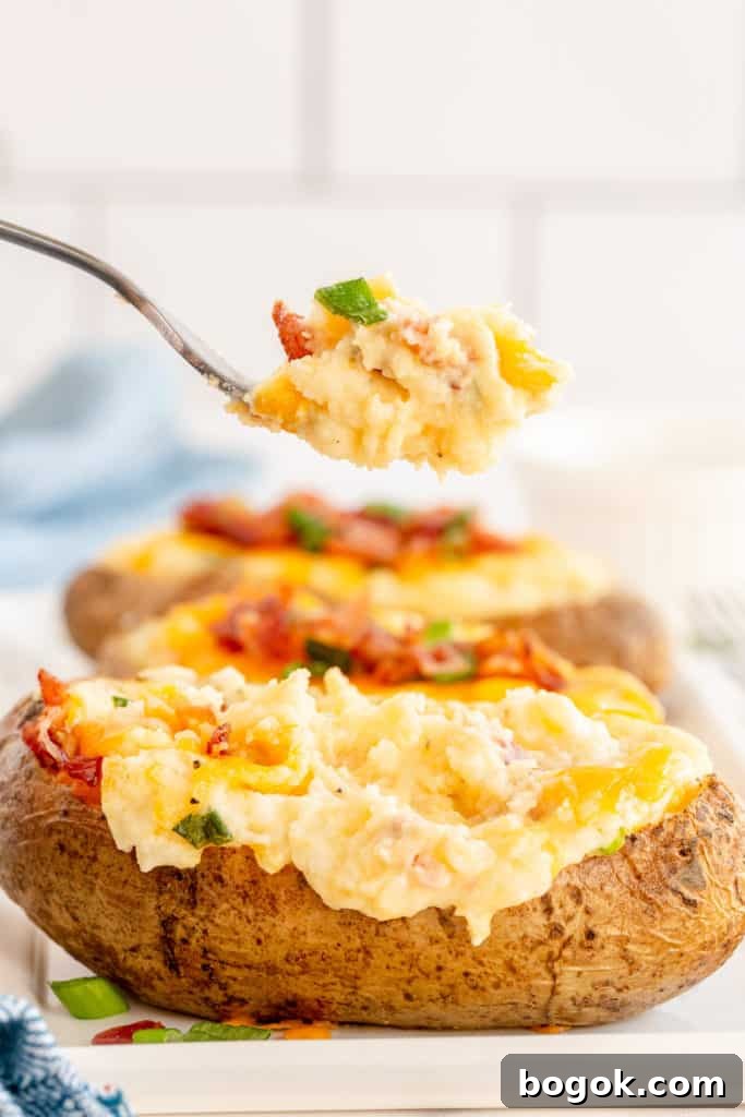 A fork lifting a bite from a twice-baked potato.