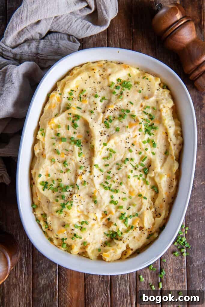 Make-ahead mashed potatoes topped with chives in a white baking dish.
