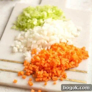 Mastering Soffritto: Classic Italian Flavor Base Recipe 6 A close up of finely chopped carrot, celery and onion on a cutting board