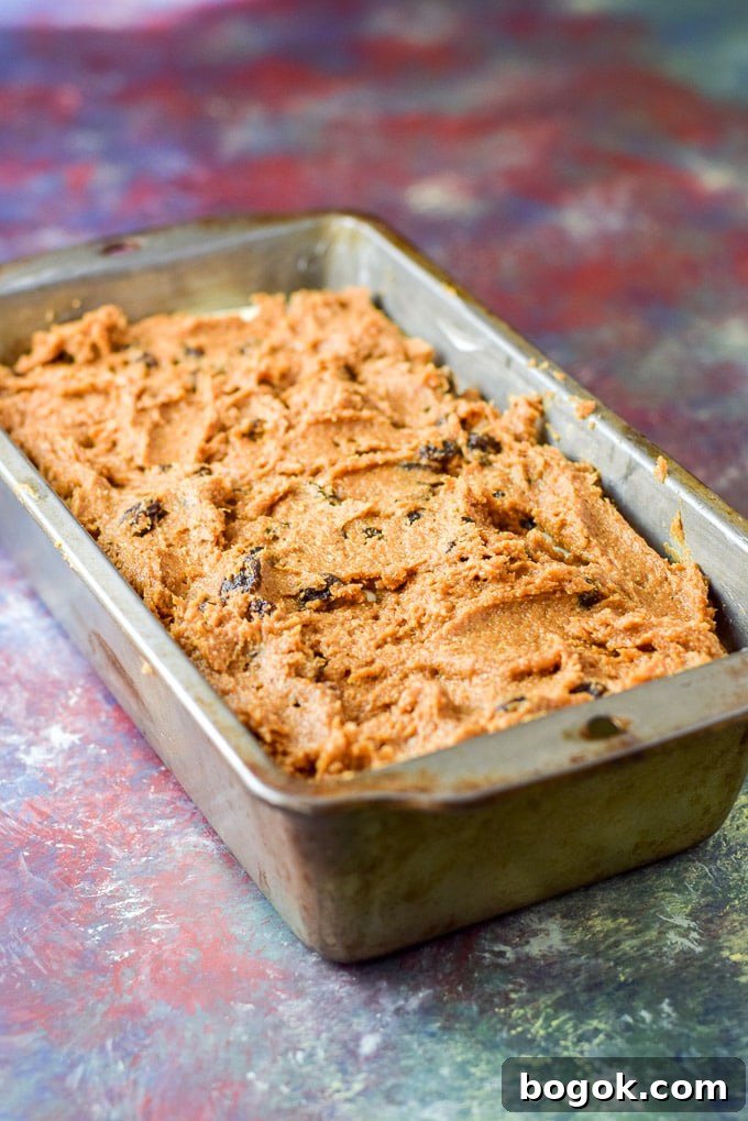 Last of the pumpkin batter spread on the cheesecake layer in the bread pan