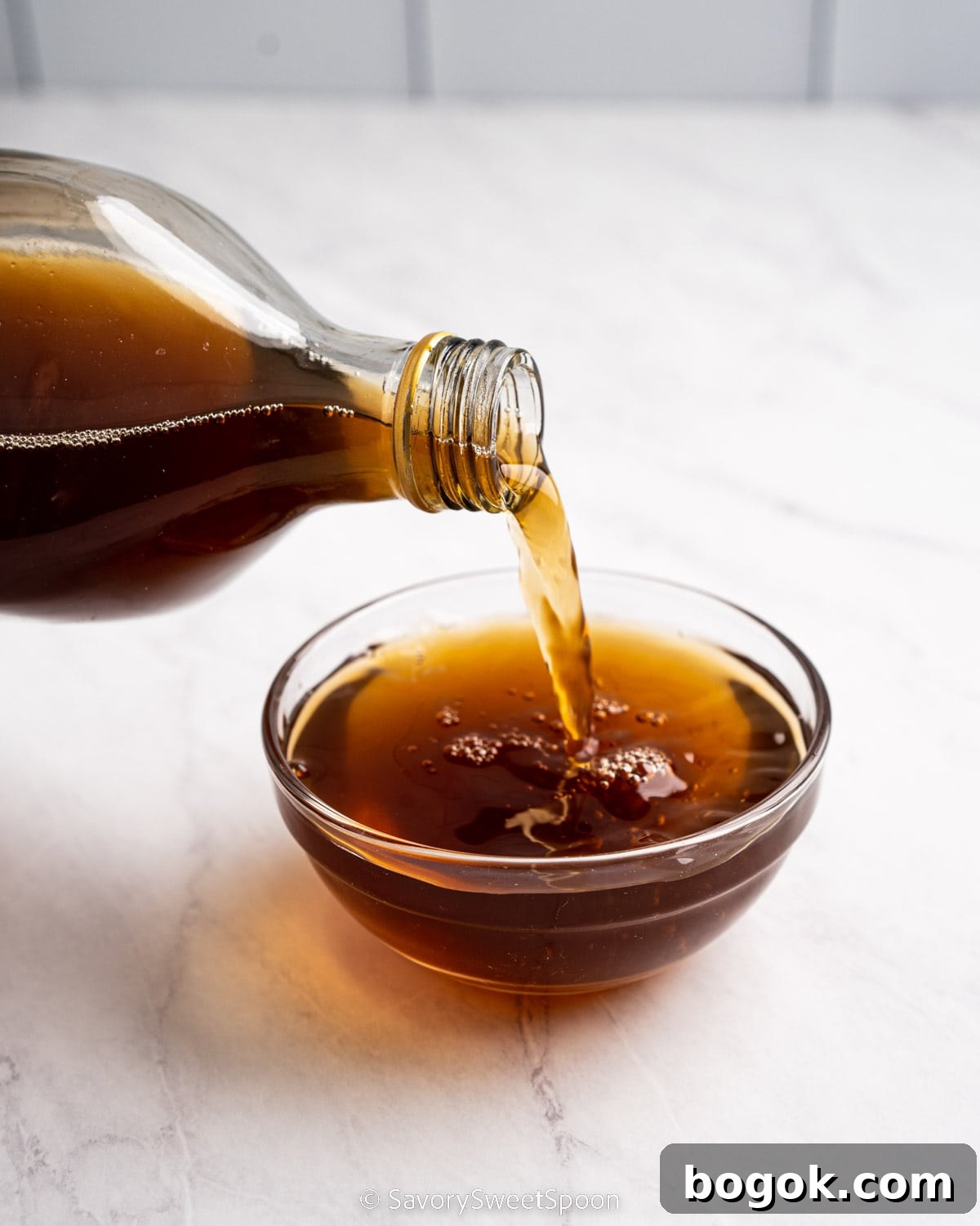 Pouring bottle of shaoxing wine into glass bowl.