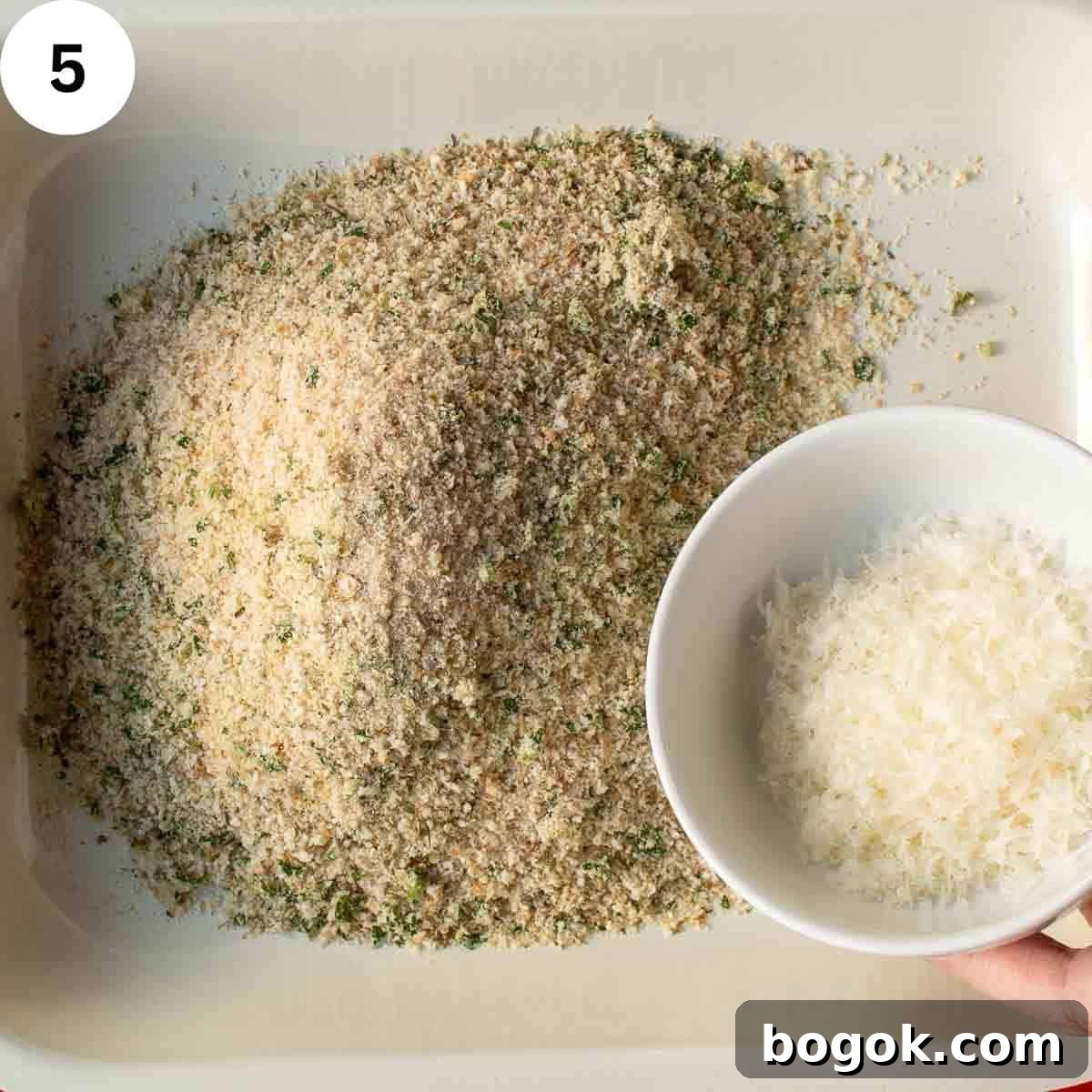Adding finely grated cheese to breadcrumbs.