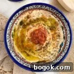 Smoky Rose Harissa: Spicy Condiment with Floral Notes 10 Top down view of preserved lemon hummus in blue bowl.