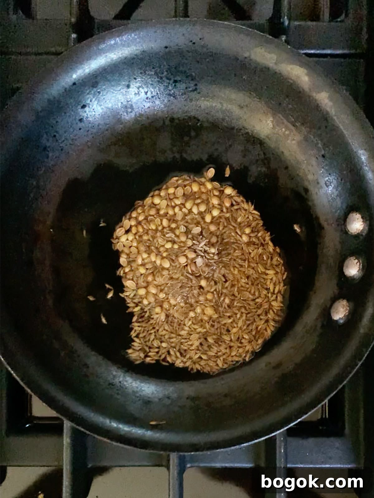 Smoky Rose Harissa: Spicy Condiment with Floral Notes 4 Whole spices for rose harissa in a frying pan.