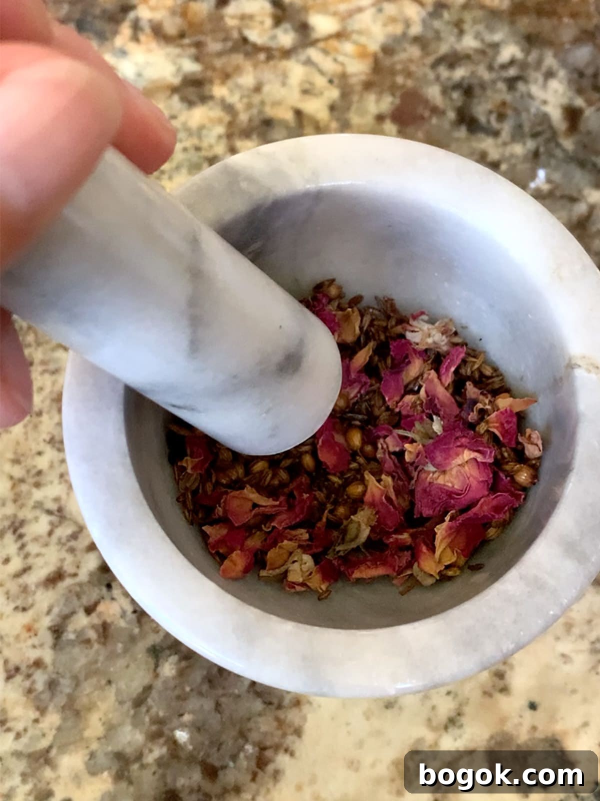 Smoky Rose Harissa: Spicy Condiment with Floral Notes 5 Spices and rose petals in mortar and pestle.