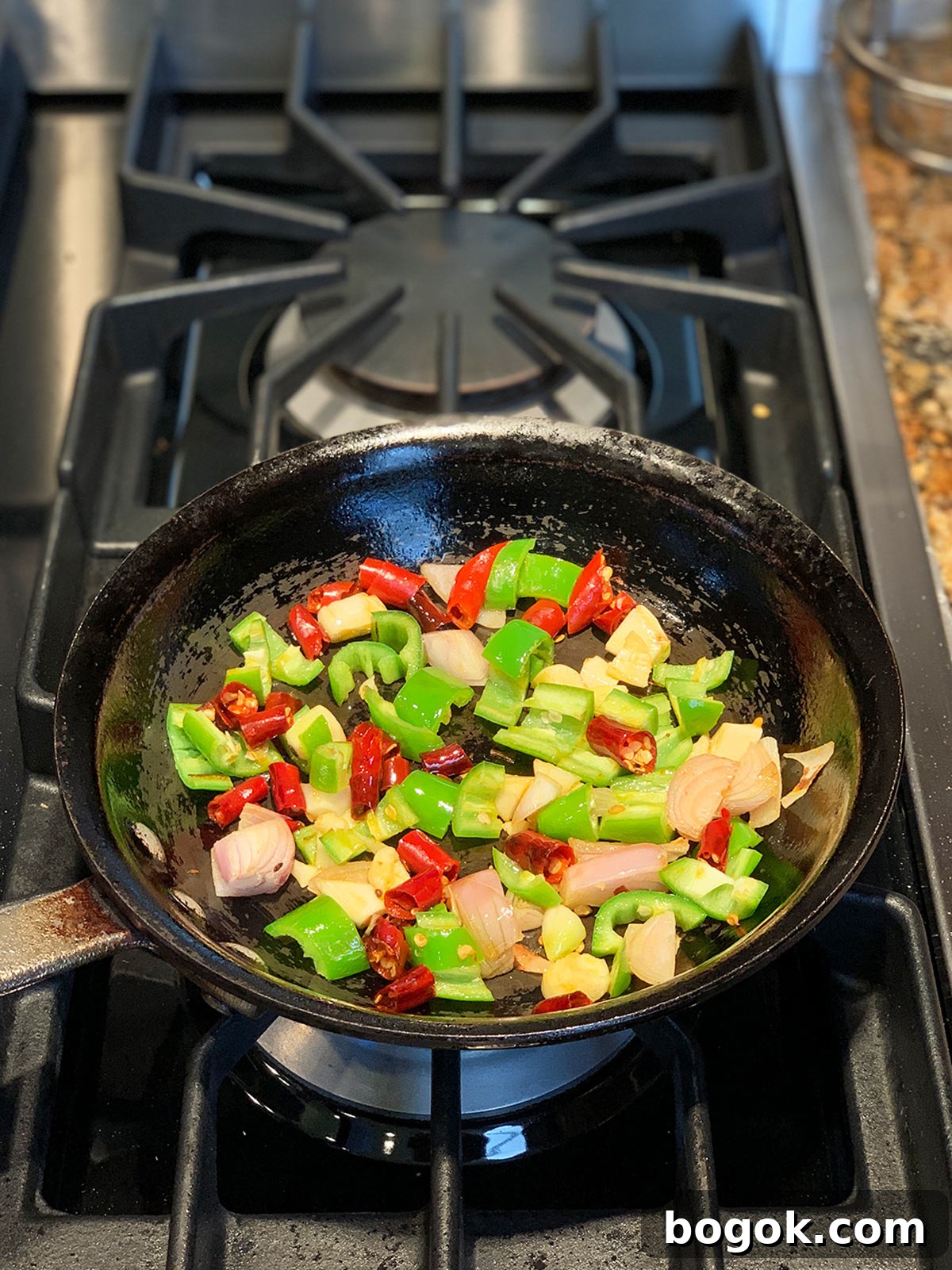 Smoky Rose Harissa: Spicy Condiment with Floral Notes 6 Peppers, shallots and garlic in saute pan.