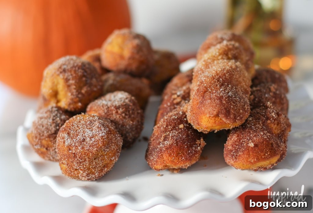 baked pumpkin donut balls and sticks on a cake stand.