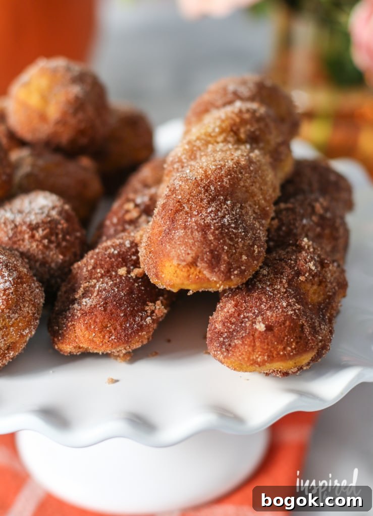 close up of baked pumpkin donuts  on a white cake stand.