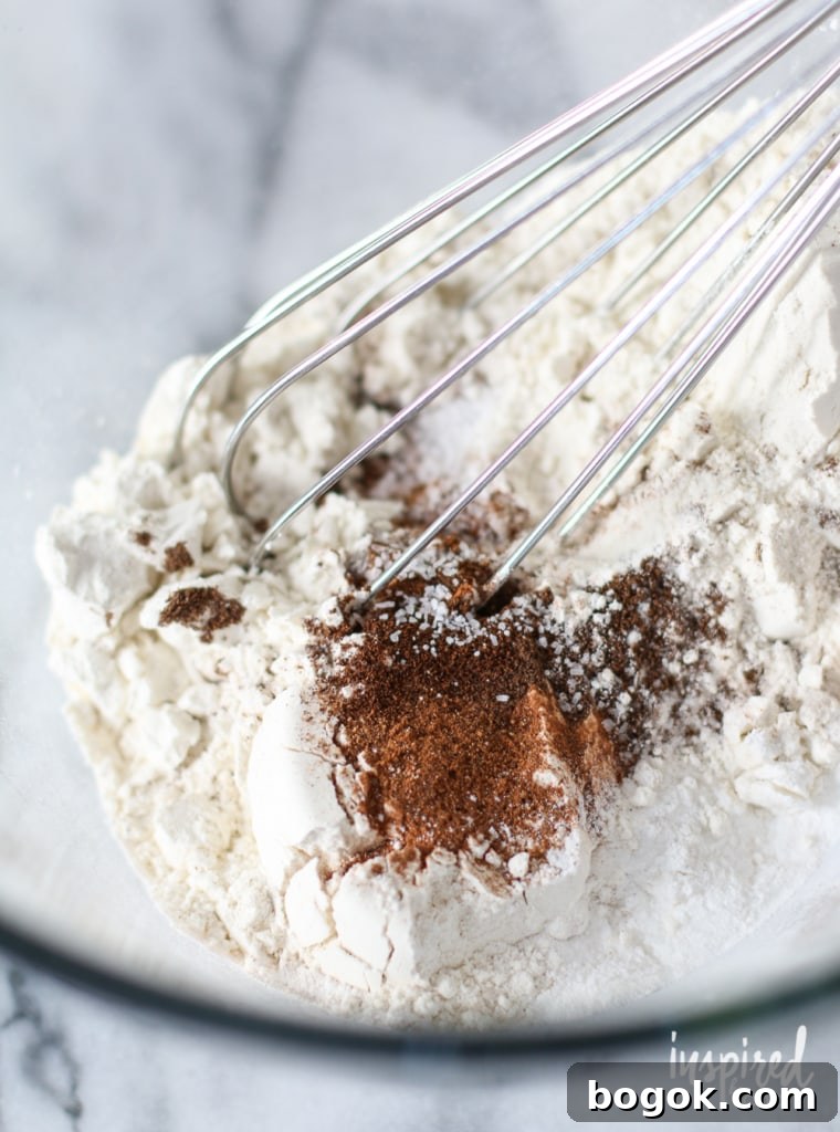 close up of whisk in dry ingredients in a bowl.