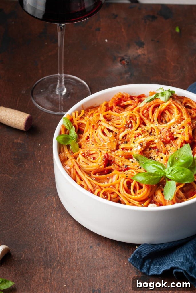 Vegan One-Pot Pasta with Classic Marinara Sauce 7 cropped serving bowl with pasta with tomato sauce and glass of wine