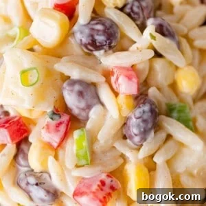 Close up view of creamy southwestern orzo salad with black beans, corn, peppers.
