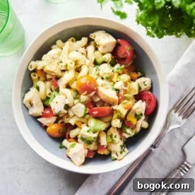 Table setting with a bowl of Pasta Salad with Chicken and a cloth napkin.