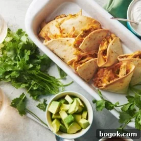 Baked chicken quesadillas in dish on table with toppings and drinks.