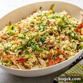 Indonesian Chicken Salad in white serving bowl on table.