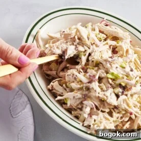 Scooping Chicken Salad out of bowl with fork.