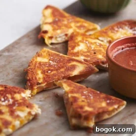 Cut Rotisserie Chicken and Cheese Quesadillas on a board with bowls of dip.