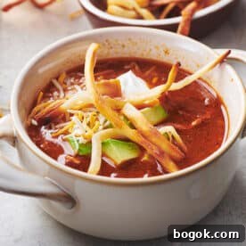 Mexican Tortilla Chicken Soup in white bowl on table.