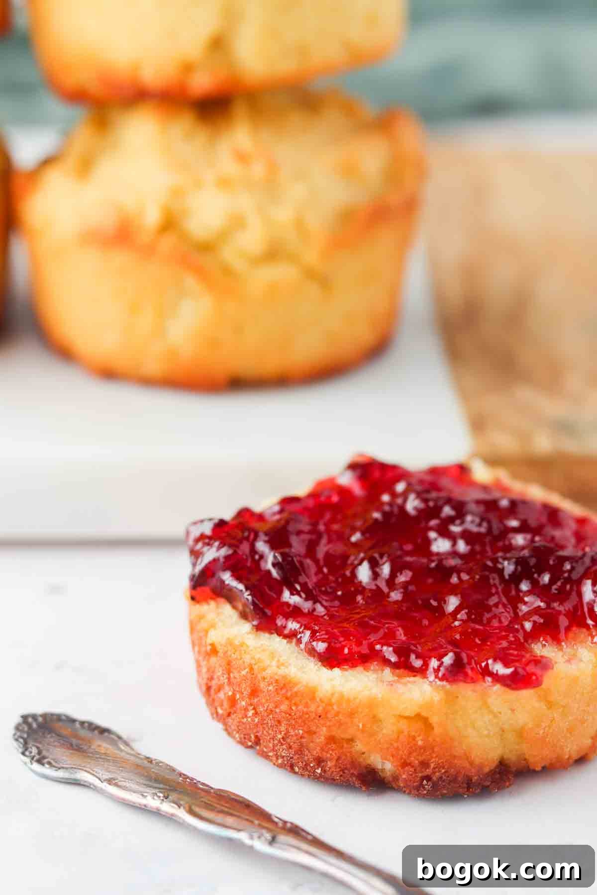 Biscuit with jelly on top sitting on a plate.