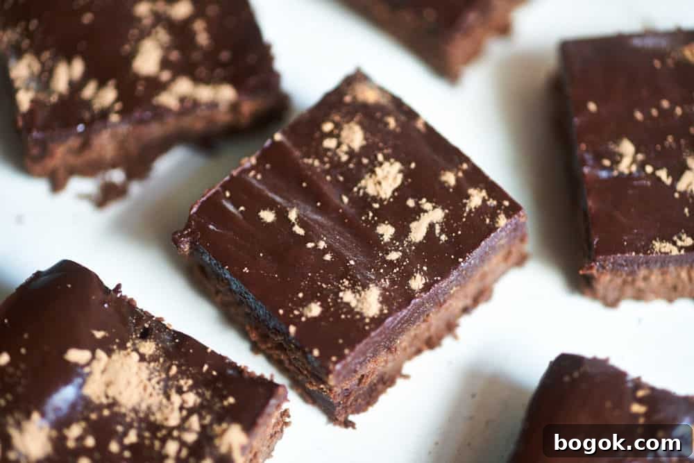 Gluten-free brownies cut into small squares and dusted with cocoa powder.