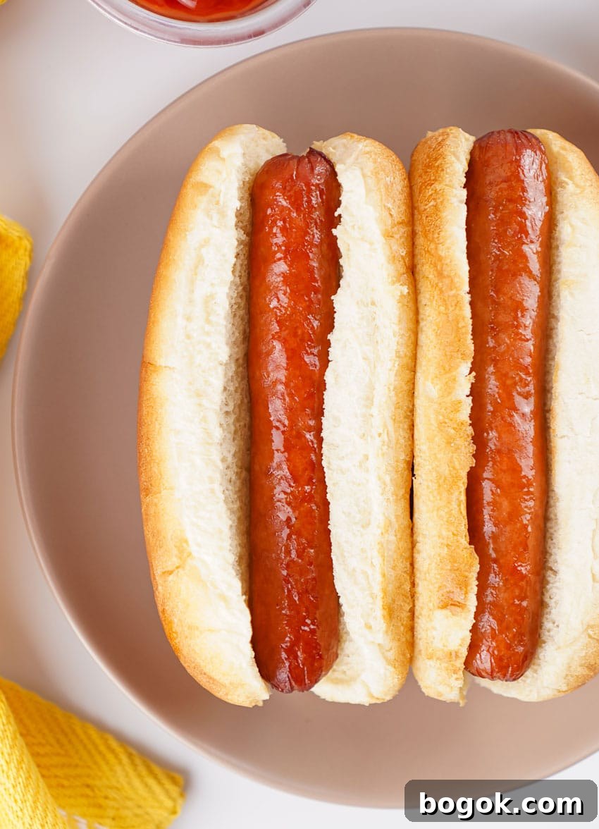 two air fried hot dogs in buns on a gray plate