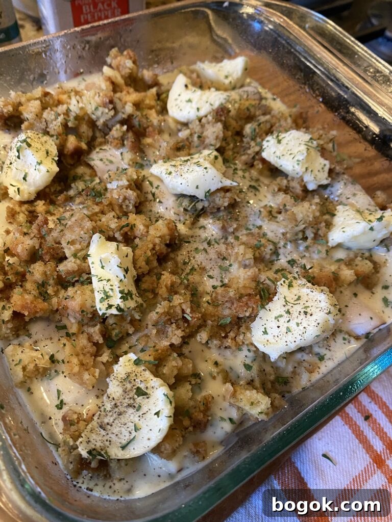 The turkey roll ups in a baking dish covered with stuffing and butter