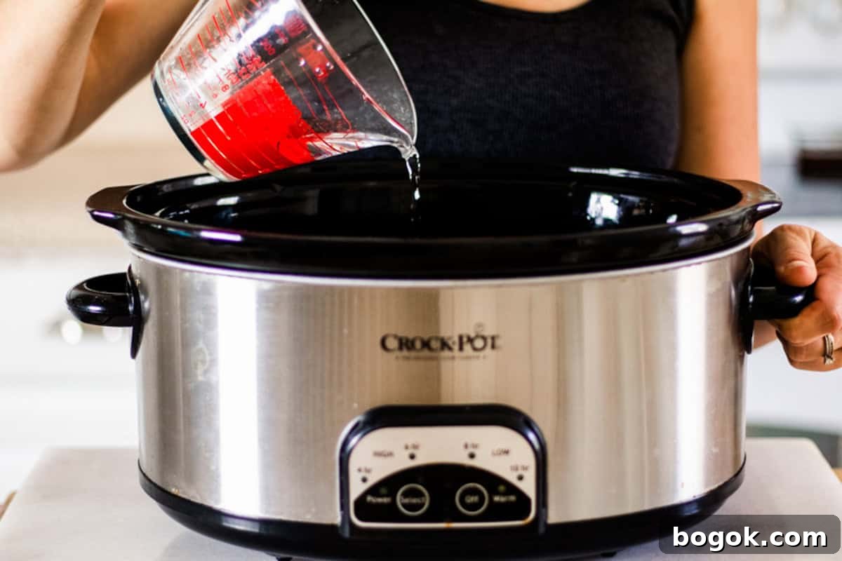 Pouring water into a crockpot.