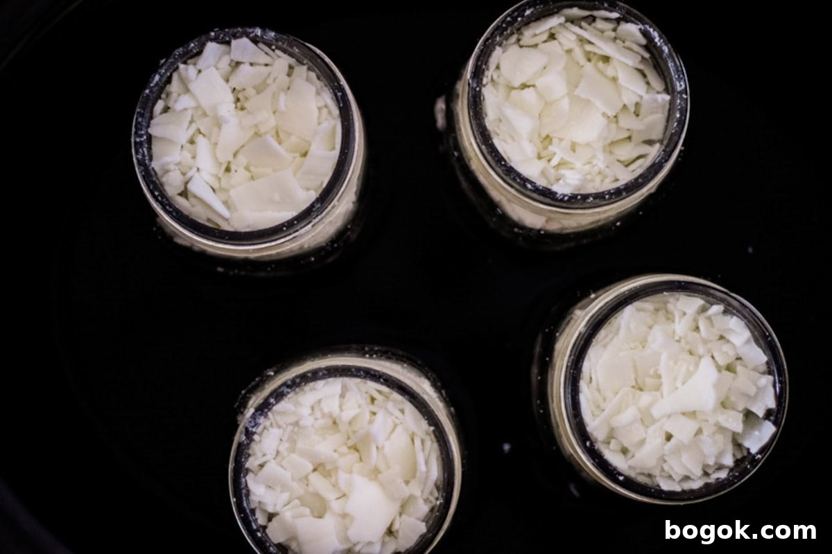 Jars of wax pellets in a crockpot, looking down.