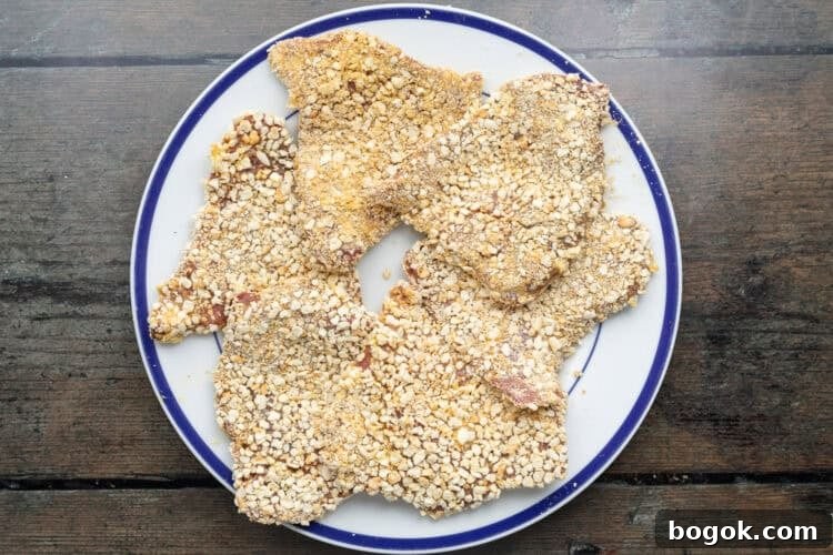 Overhead view of breaded beef schnitzel steaks on a plate.
