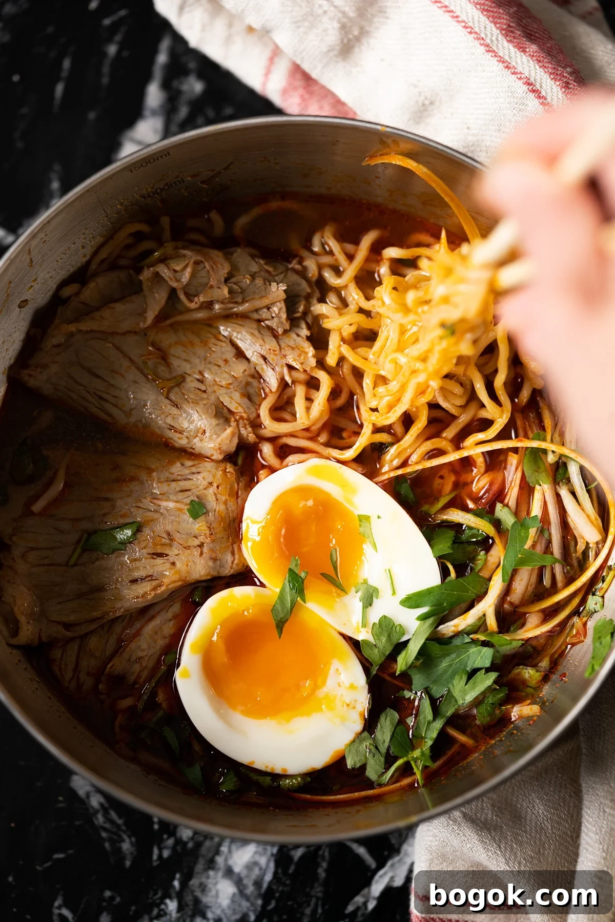 Paleo Keto Ramen with Shirataki Noodles: Low-Carb Comfort Bowl 4 Taking keto shirataki noodles in a ramen soup with chop sticks