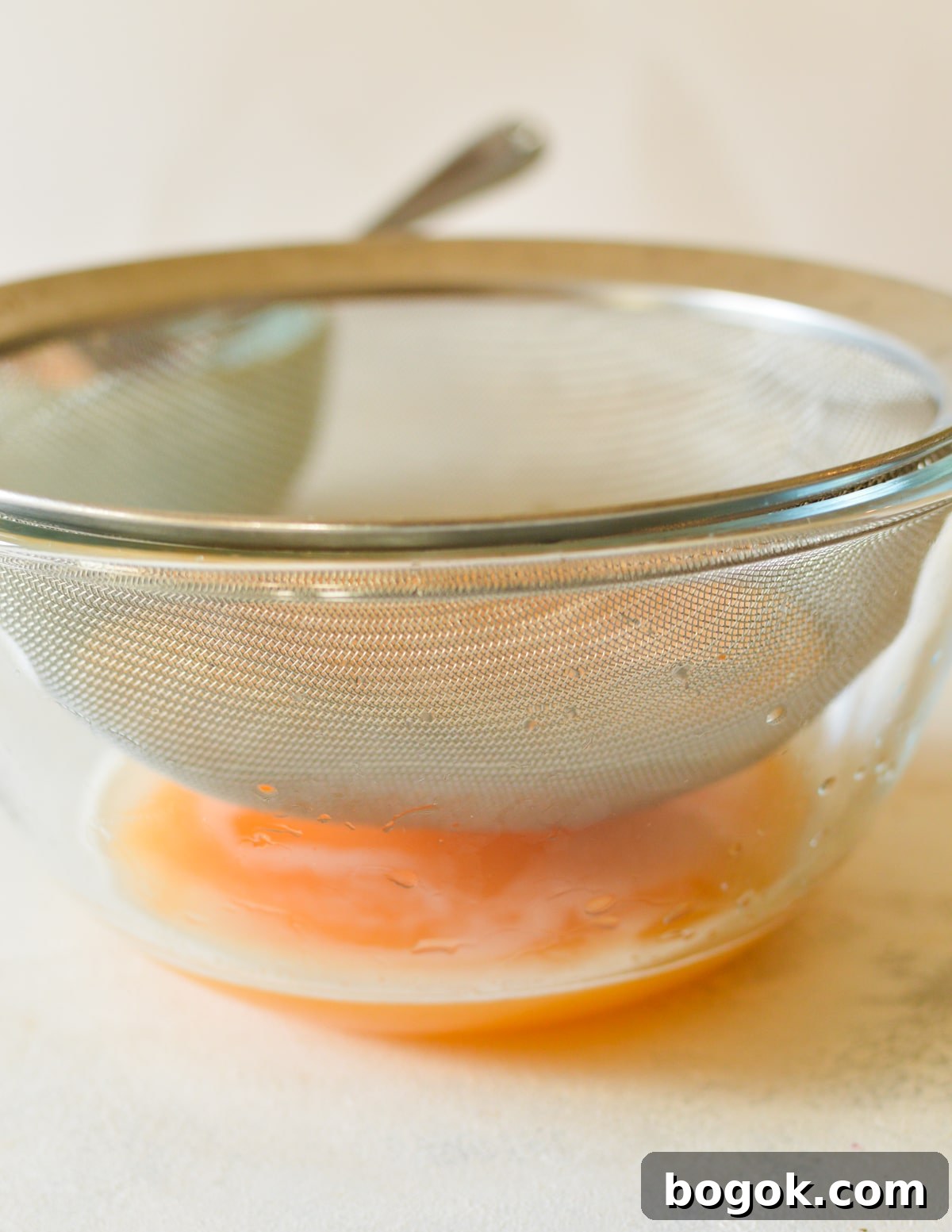 Refreshing Cantaloupe Juice Recipe: Cold, Natural & Delicious 14 bowl of cantaloupe juice with sieve above it,