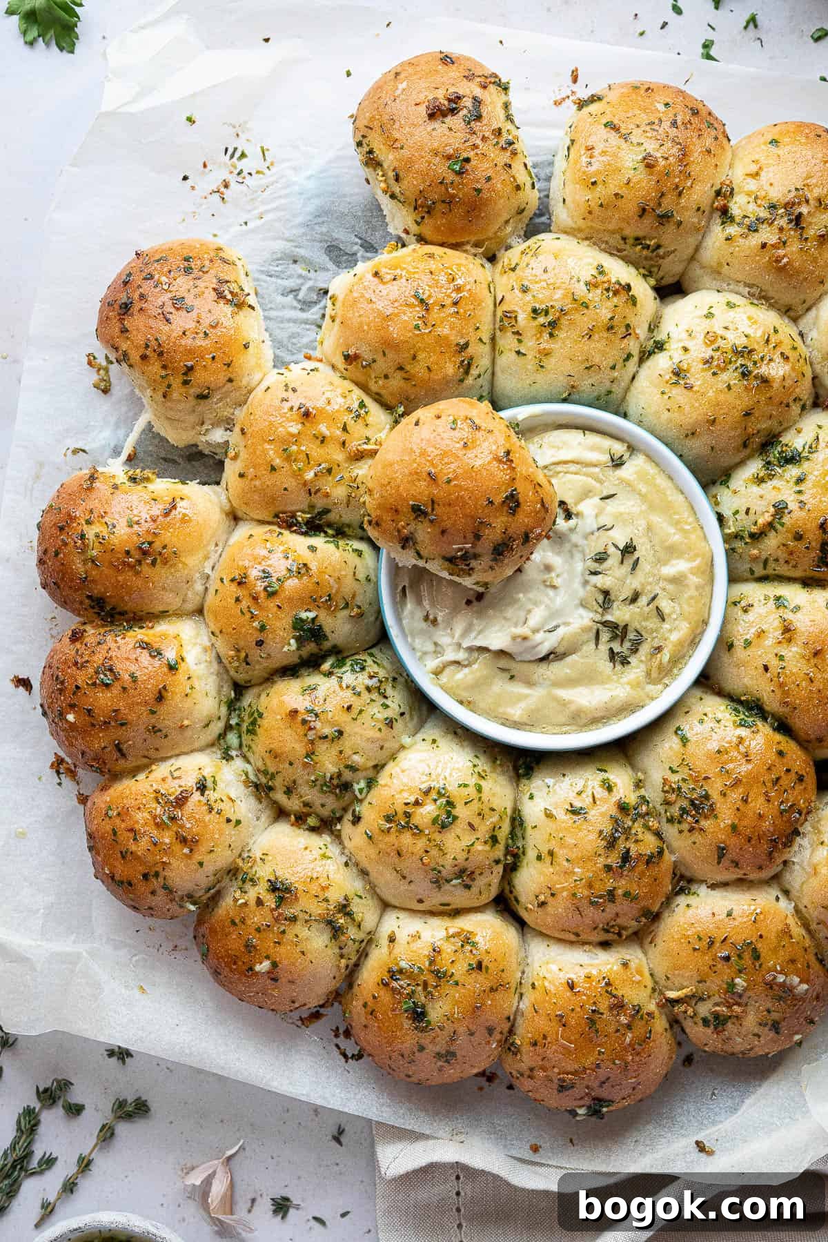 Close up of the vegan garlic dough balls, one placed in the cheese dip.