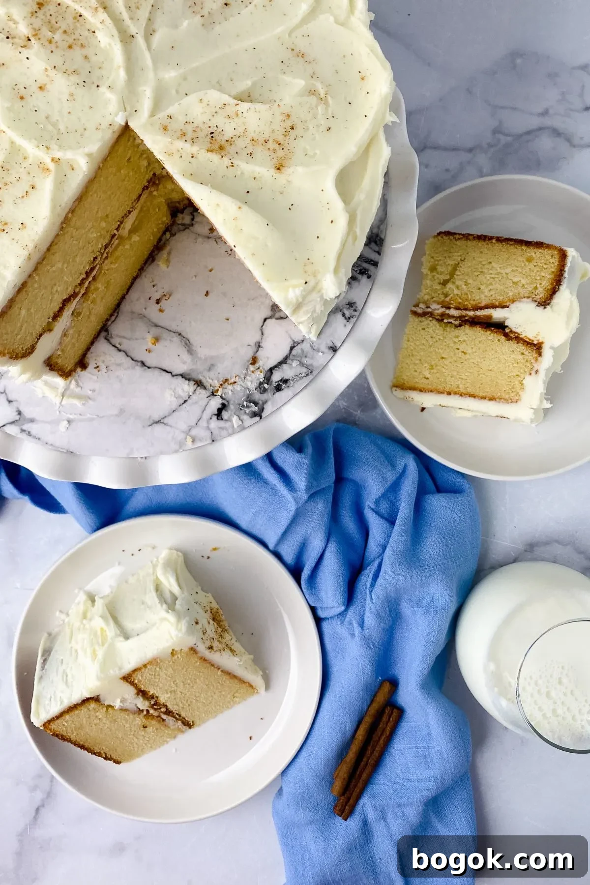 Looking down on eggnog cake with slices on plates.
