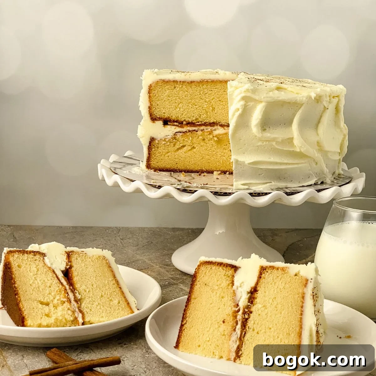 Two slices of cake from an eggnog cake on a pedastal.