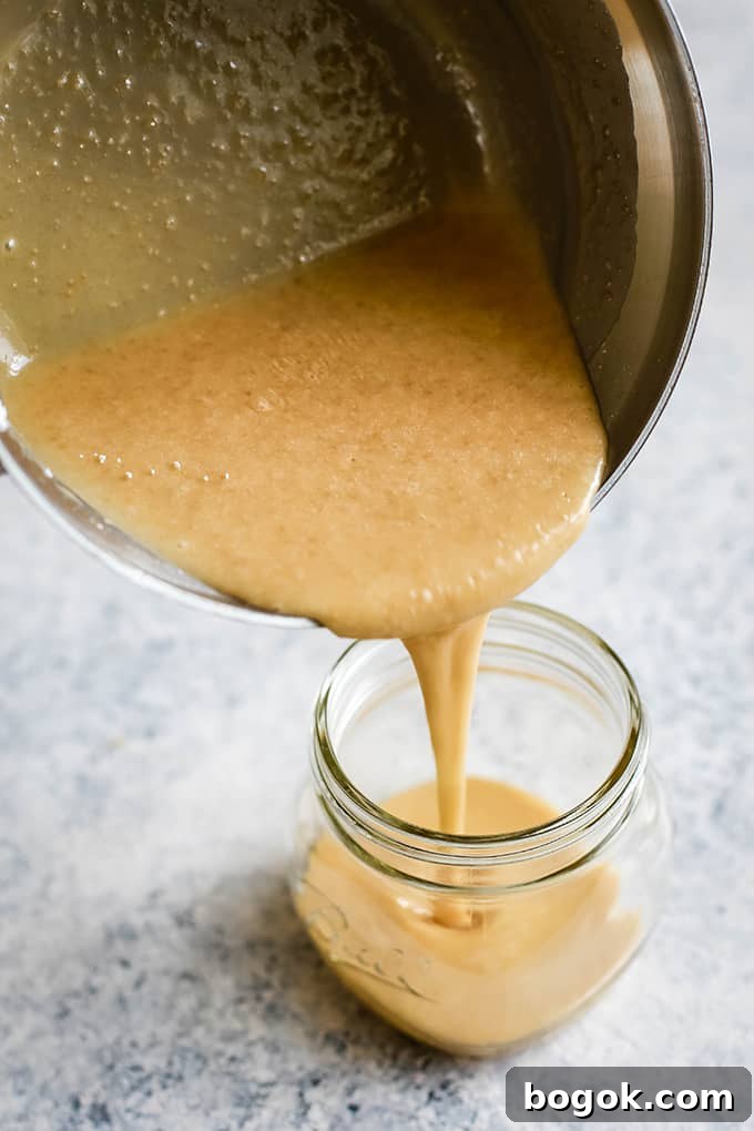 This Homemade Caramel Icing recipes takes just seven minutes to prepare and uses only five ingredients. EASY. If you can use a whisk, you'll be an icing expert for sure. Homemade Caramel Icing is poured from a sauce pan into a glass jar.