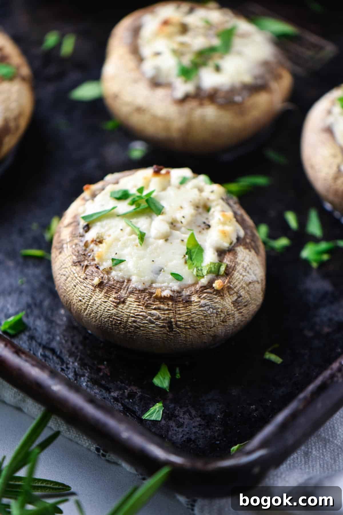 Boursin-Stuffed Mushrooms with Garlic and Herbs 2 A cheese stuffed mushroom on a baking sheet after baking.